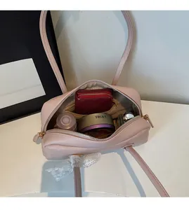 Vue macro de l'intérieur spacieux du sac Boston en cuir rose avec fermeture dorée