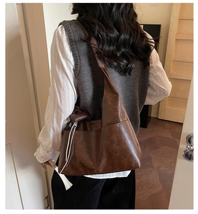 Deep brown large faux leather tote bag showing slouchy drape and side pocket detail