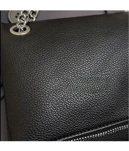 Dettaglio borsa nera in similpelle a grana litchi con catena e occhielli in argento