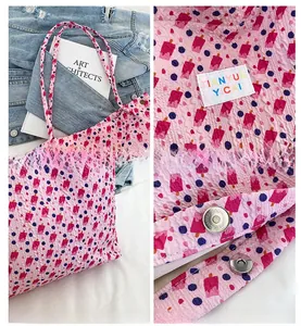 Detail view of pink floral tote with popsicle patterns, textured fabric and magnetic clasp