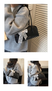 Detail of lychee pattern leather handbag featuring white lace bow and gold logo