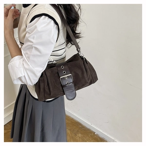 Détail du sac à bandoulière en daim chocolat avec design plissé et boucle argentée vintage
