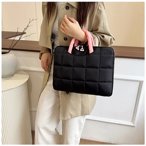 Detail of quilted laptop bag with pink handles and triangle zipper pull accents