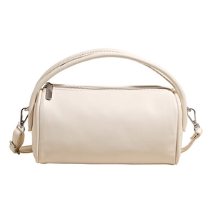 Detailed view of cream leather cylinder bag with silver zipper and metallic hooks