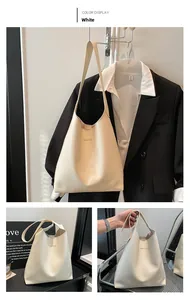 Detailed view of white minimalist tote bag with FASHION lettering and slim shoulder strap