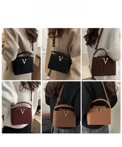 Detail showing various colors of leopard print handbags with gold V-shaped metal logo