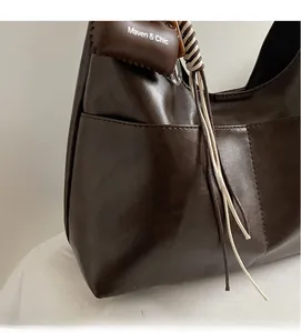 Detailed close-up of dark brown hobo tote bag featuring soft leather texture and fine stitching