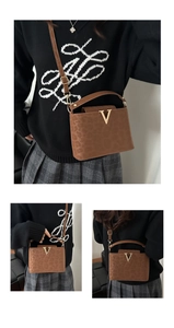 Detail of leopard print crossbody bag featuring a golden V logo and adjustable shoulder strap