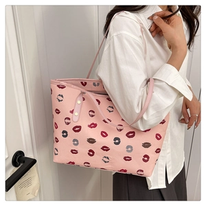 Detail view of the pink faux leather tote bag with multi-colored lip patterns on model