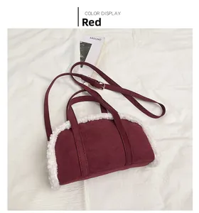 Détail du sac à main en daim rouge avec bordure en laine blanche et bandoulière