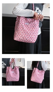 Detail of floral tote bag showing pink bubble fabric texture and brand label