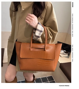 Brown crocodile pattern leather tote bag styled with laptop and office accessories
