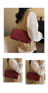 Dettaglio borsa baguette in pelle martellata rossa con catena argento e nappa