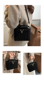 Detail showing leopard print texture, golden V-buckle, and crossbody strap of the bag