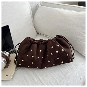 Détail du sac à cordon en daim marron vintage orné de clous dorés décoratifs