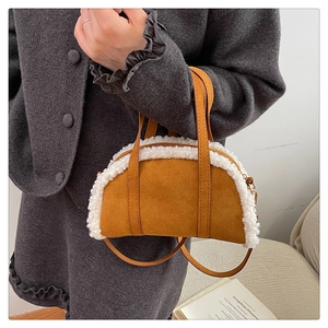 Gros plan d'un sac à main en daim marron avec bordure en laine et double poignées