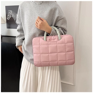 Detail of pink quilted 14-inch laptop bag with light green handles and triangle zippers