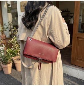 Dettaglio borsa squadrata in pelle rosso scuro con catena argento e cerniere decorative