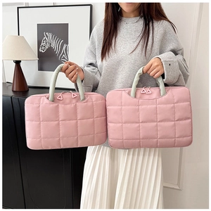 Comparison of two pink quilted laptop bags in different sizes with green handles