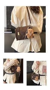 Detail of retro coffee brown box bag with gold swivel lock and cute teddy bear charm