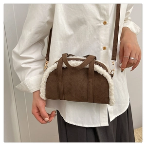 Détail d'un sac bandoulière en daim marron avec bordure en fausse fourrure blanche