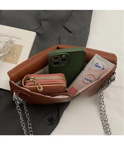 Détail de l'intérieur du sac en cuir marron montrant l'espace pour téléphone et portefeuille