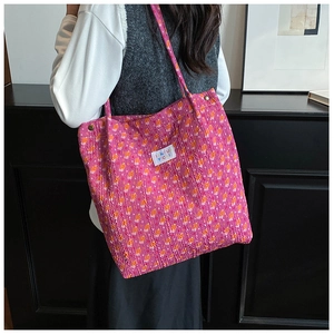 Detailed texture of rose pink floral tote bag with wrinkled fabric and logo label