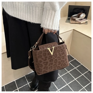 Detail shot of leopard print handbag with golden V-logo buckle in a modern lifestyle setting