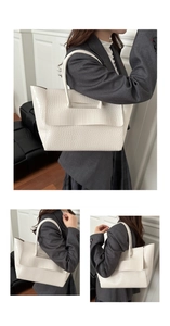 Close-up of white crocodile pattern texture and handle detail on a large tote bag