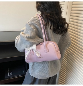 Détail du sac Boston violet avec nœud en dentelle blanche et lettrage doré
