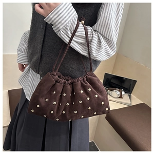 Détails du sac seau en daim marron foncé avec rivets métalliques et cordon de serrage