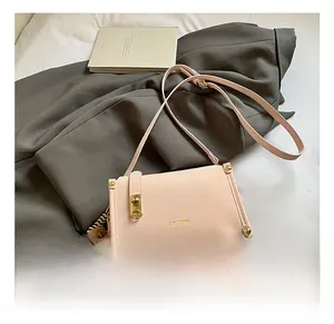 Detail of pink leather handbag with gold lock and cute brown plush bear charm