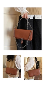 Détail du sac en cuir marron à motif litchi avec chaîne argentée et doubles glands zippés