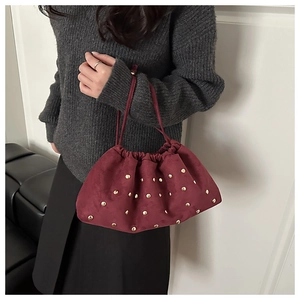 Détail du sac nuage en velours bordeaux avec clous dorés et fine bandoulière