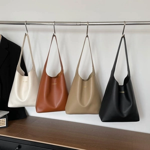 Minimalist large leather tote bags in four colors hanging on a modern metal rack