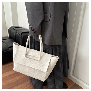 Side view of a woman wearing a cream crocodile pattern tote bag for office commuting