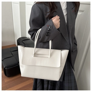 Close-up of white crocodile pattern tote bag with high-quality texture and double handles
