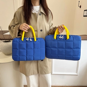 Quilted blue laptop bag for 14-inch computers with bright yellow handles and zip closure