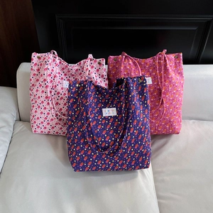Three stylish floral canvas tote bags with patterns on a white leather sofa