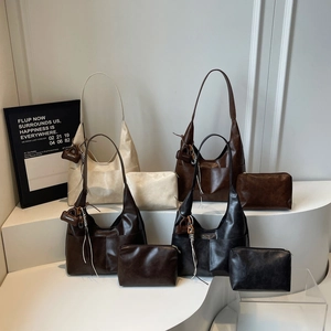 Minimalist large leather tote bag set in four colors on a tiered display stand
