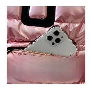 Détail de la poche zippée sur sac matelassé rose métallisé avec smartphone de mesure