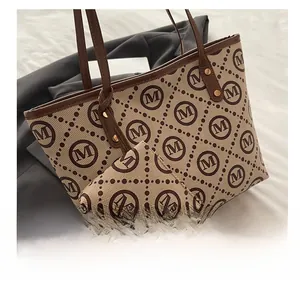 Detail view of large tote bag with matching coin purse featuring beige M-pattern canvas