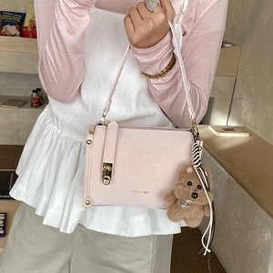 Pink minimalist box bag with golden metal clasp and cute brown bear pendant on a shoulder strap
