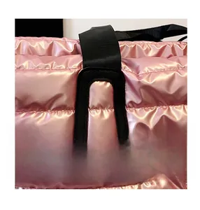 Gros plan des coutures renforcées sur la poignée du sac matelassé rose métallisé durable