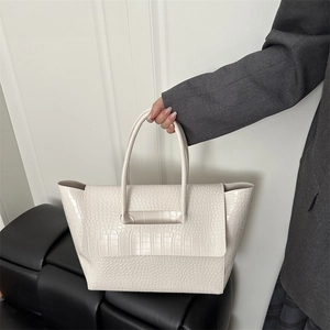 Minimalist beige tote bag with crocodile texture and top handle in modern style