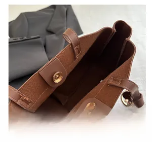Detailed close-up of the vintage brown tote bag showing gold magnetic buckle and soft lining