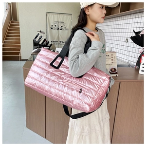 Détail du sac fourre-tout rose matelassé avec fini métallisé et sangle noire