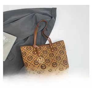 Gros plan du sac cabas marron avec motif monogramme M et pendentif en métal doré