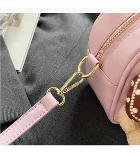 Macro detail of pink leather bowling bag showing light gold D-ring and smooth zipper