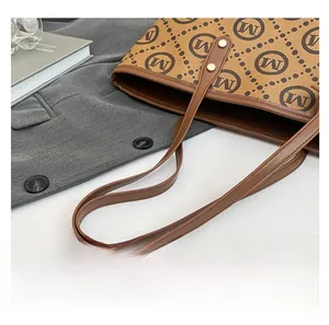 Vue détaillée de la poignée en cuir avec rivets dorés sur le sac fourre-tout vintage